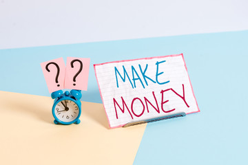 Handwriting text Make Money. Conceptual photo making a profit or giving the opportunity to make a profit Mini size alarm clock beside a Paper sheet placed tilted on pastel backdrop