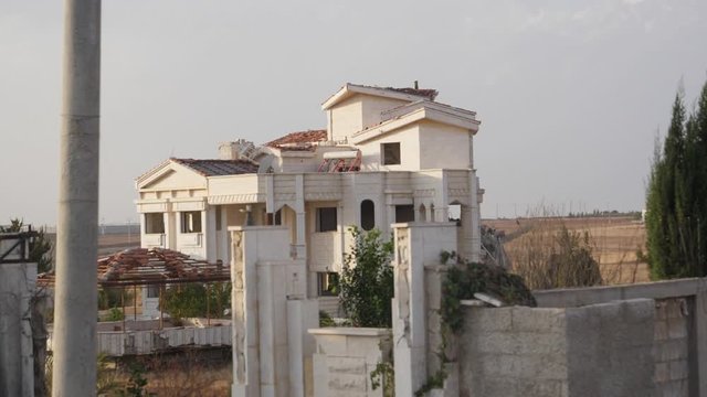Slow moving video, passing through a big white Villa on a road near Damascus.