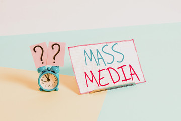 Handwriting text Mass Media. Conceptual photo Group showing making news to the public of what is happening Mini size alarm clock beside a Paper sheet placed tilted on pastel backdrop