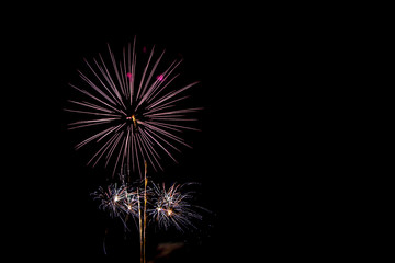 Fireworks light up on dark sky background.