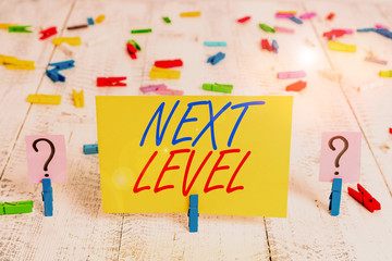 Writing note showing Next Level. Business concept for having more than one floor and referring to after current Crumbling sheet with paper clips placed on the wooden table