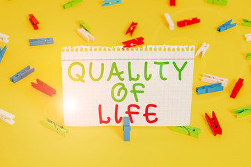 Handwriting text Quality Of Life. Conceptual photo being in good health decent job Enjoying every moment Colored clothespin papers empty reminder yellow floor background office