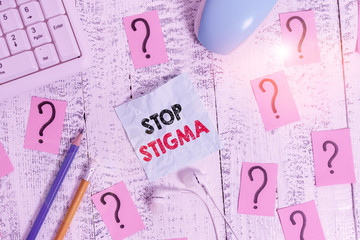 Writing note showing Stop Stigma. Business concept for end the feeling of disapproval that most showing in society have Writing tools and scribbled paper on top of the wooden table