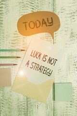 Writing note showing Luck Is Not A Strategy. Business concept for it is not being Lucky when planned intentionally Envelop speech bubble paper sheet ballpoints notepads wooden background