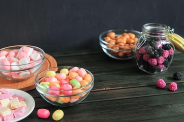 multi-colored candies in a plate, bank and bowls with copy space - 305598799