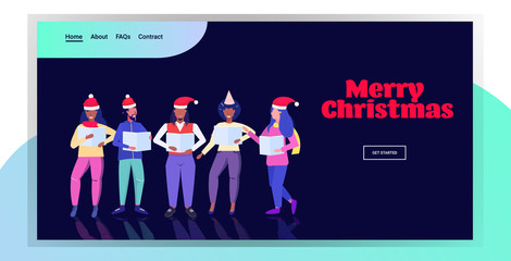 mix race people holding sheet books and giving performance merry christmas happy new year holidays celebration concept men women standing together full length horizontal greeting card vector