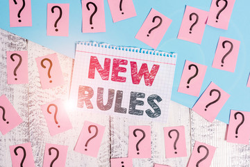 Text sign showing New Rules. Business photo showcasing recently one of a set of explicit or understood regulations Scribbled and crumbling papers with thick cardboard above wooden table