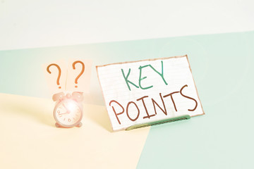 Handwriting text Key Points. Conceptual photo most important piece of information that is said or written Mini size alarm clock beside a Paper sheet placed tilted on pastel backdrop