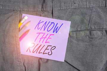 Writing note showing Know The Rules. Business concept for Learn the accepted principle or instructions to follow Writing equipment and purple note paper inside pocket of trousers