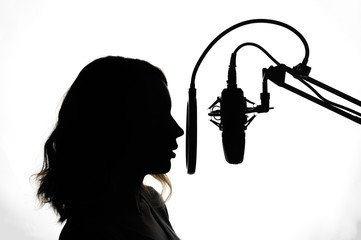 Silhouette of a girl with a studio microphone, radio presenter, singer and blogger, voice acting...