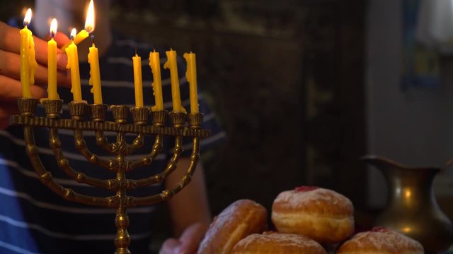 Jewish Family lighting Hanukkah Candles in a menorah for the holdiays