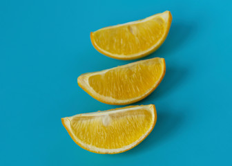 Bright juicy slices of lemon on a blue background. Yellow lemon. Citrus.