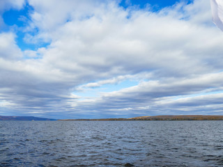 a large reservoir in the autumn cloudy sky and hill