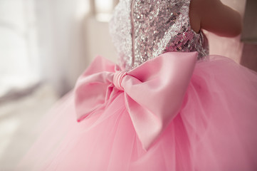 adorable puffy pink dress for a girl from tulle, with a huge pink bow on the back, shiny silver sequin back