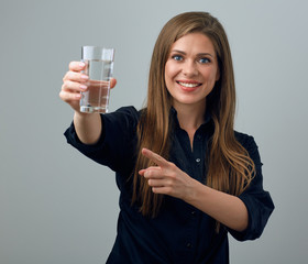 woman holding water glass in front of her and pointing with finger.