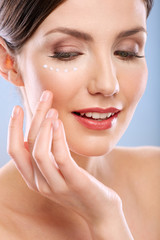 Obraz na płótnie Canvas Woman touching face with white cream points on clean skin.