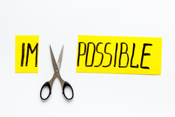 All is possible concept. Cut word impossible near scissors on white background