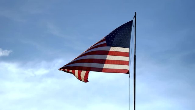 American flag waving against a background of blue sky
