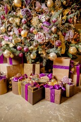 Christmas background with purple, golden decoration, presents.Christmas decoration. purple gift boxes under Christmas tree . winter, new year concept.New Year's Eve with decorations. Selective focus
