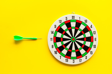Goal achievement concept. Dartboard and arrows or dart on yellow background top view copy space