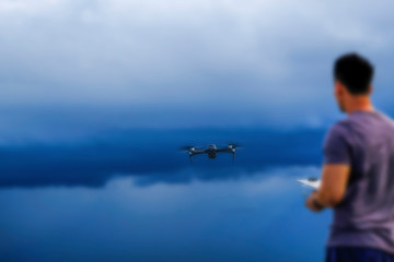 Blurred background of man operating drone over the river for background