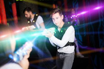 Excited guy laser tag player in bright beams