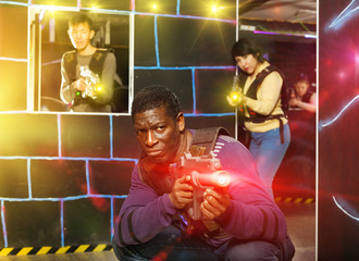 African man playing laser tag with friends