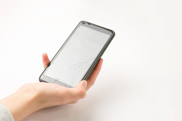 Smartphone in hand on a white background. Broken screen