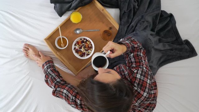 Image of woman drinking coffee during the breakfast at bed.
