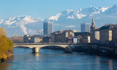 Fototapeta premium Cable cars over river and bridge in Grenoble in autumn
