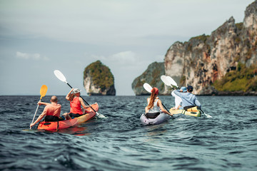 Group of friends walks by sea kayaks