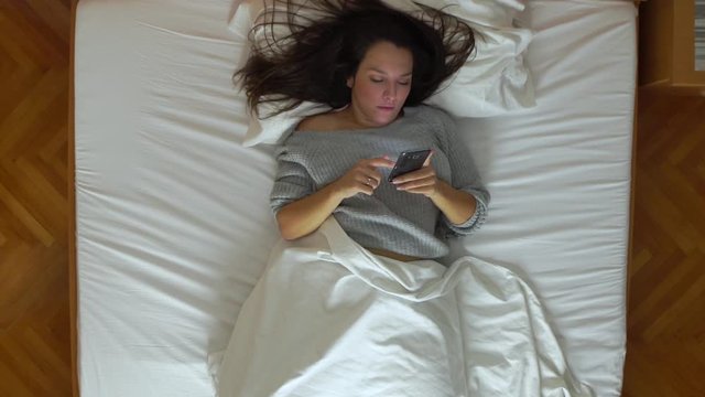 Image from above of woman using the cell phone during the night.
