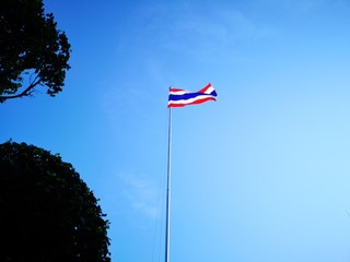 Fototapeta premium Waving Thai flag of Thailand with a blue background on a cold day