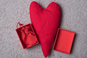 Red heart with a gift box. Studio image. Red box with a gift and fabric heart for Valentine's Day.