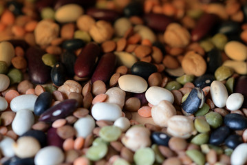 Different beans scattered on a wooden surface close-up. Naturel organic food background
