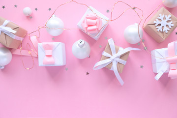 Christmas background with decorations and gift boxes on pink background