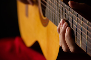 female hands hold an acoustic guitar. play music.