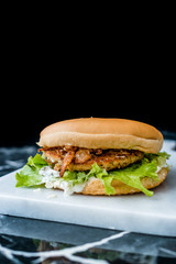 Homemade Salmon Burger with Tartar Sauce, Onion and Lettuce on Marble Board.