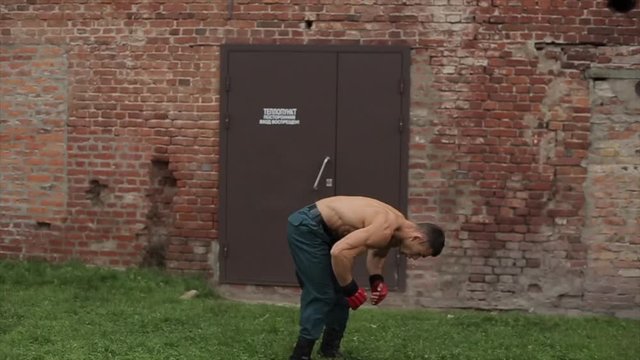 Strong young man doing back flip outdoors
