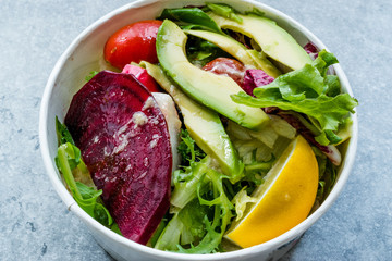 Healthy Fast Food Take Away Salad with Avocado, Beet Slice, Lettuce, Cherry Tomatoes and Sauce in Plastic Box / Package or Container.