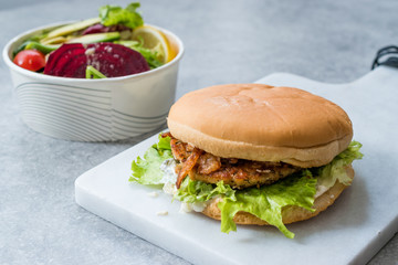 Fast Food Menu Salmon Burger with Take Away Salad in Plastic Box.