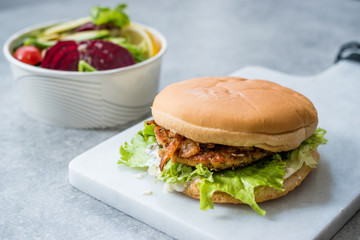 Fast Food Menu Salmon Burger with Take Away Salad in Plastic Box.