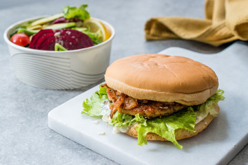 Fast Food Menu Salmon Burger with Take Away Salad in Plastic Box.