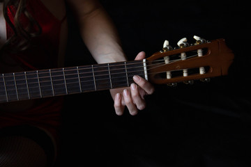 female hands hold an acoustic guitar. play music.