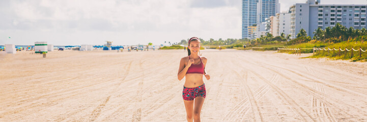 Running woman jogging on South beach, Miami, Florida banner panorama. Fit Asian woman doing cardio...