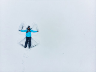 overhead view woman making snow angel