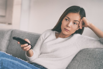 Bored woman watching boring tv shows having nothing to watch on television. Movie night sucks.