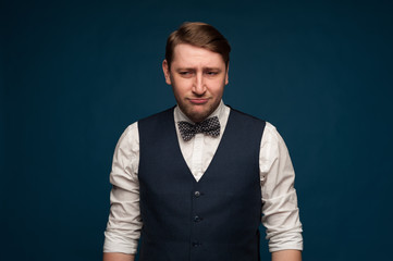 Sad young man in formal clothes looks upset