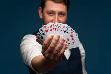 Man holding showing poker cards on blue background