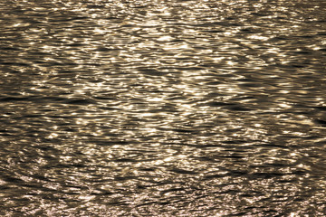 Golden glisten of sunlight reflects on the sunset sea surface